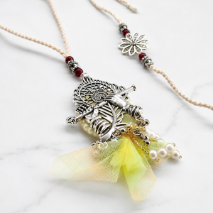 Closer view of flute rakhi and flower rakhi set.