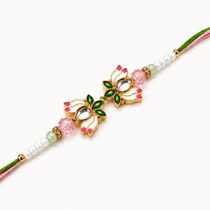 Close-up view of lotus design rakhi with beads, green & pink threads