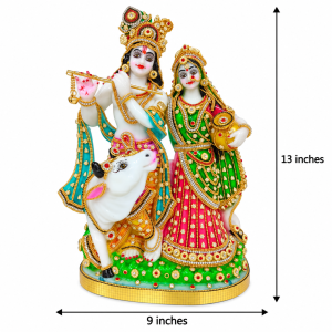 Decorative Radha Krishna idol with a sacred Kamdhenu cow, featuring colorful stone and pearl embellishments on a golden base.