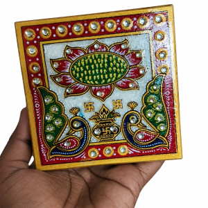 A traditional hand-painted marble pooja chowki featuring a peacock, lotus, and kalash design.